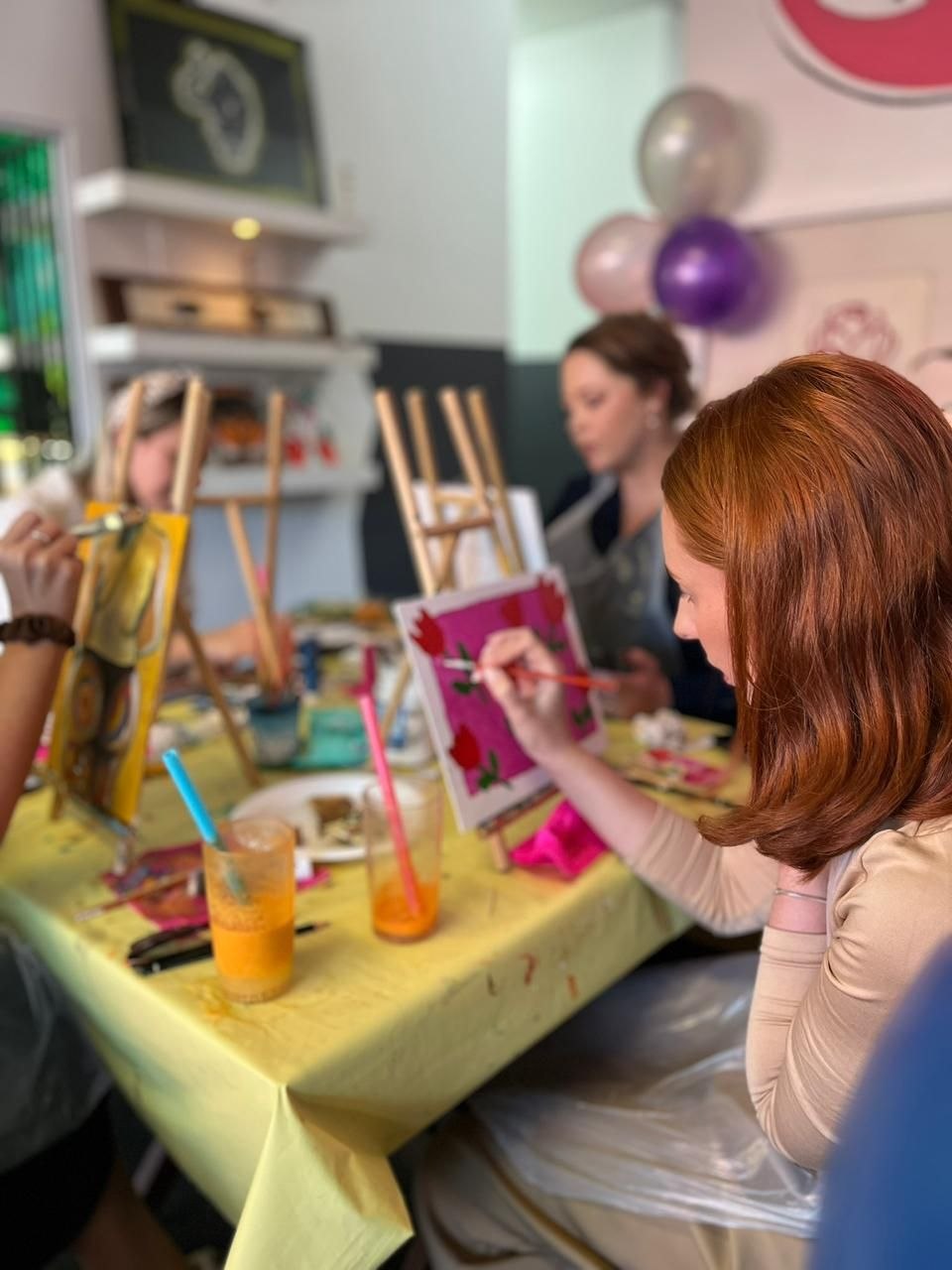 Guests painting together around a table at Life Is Good Café